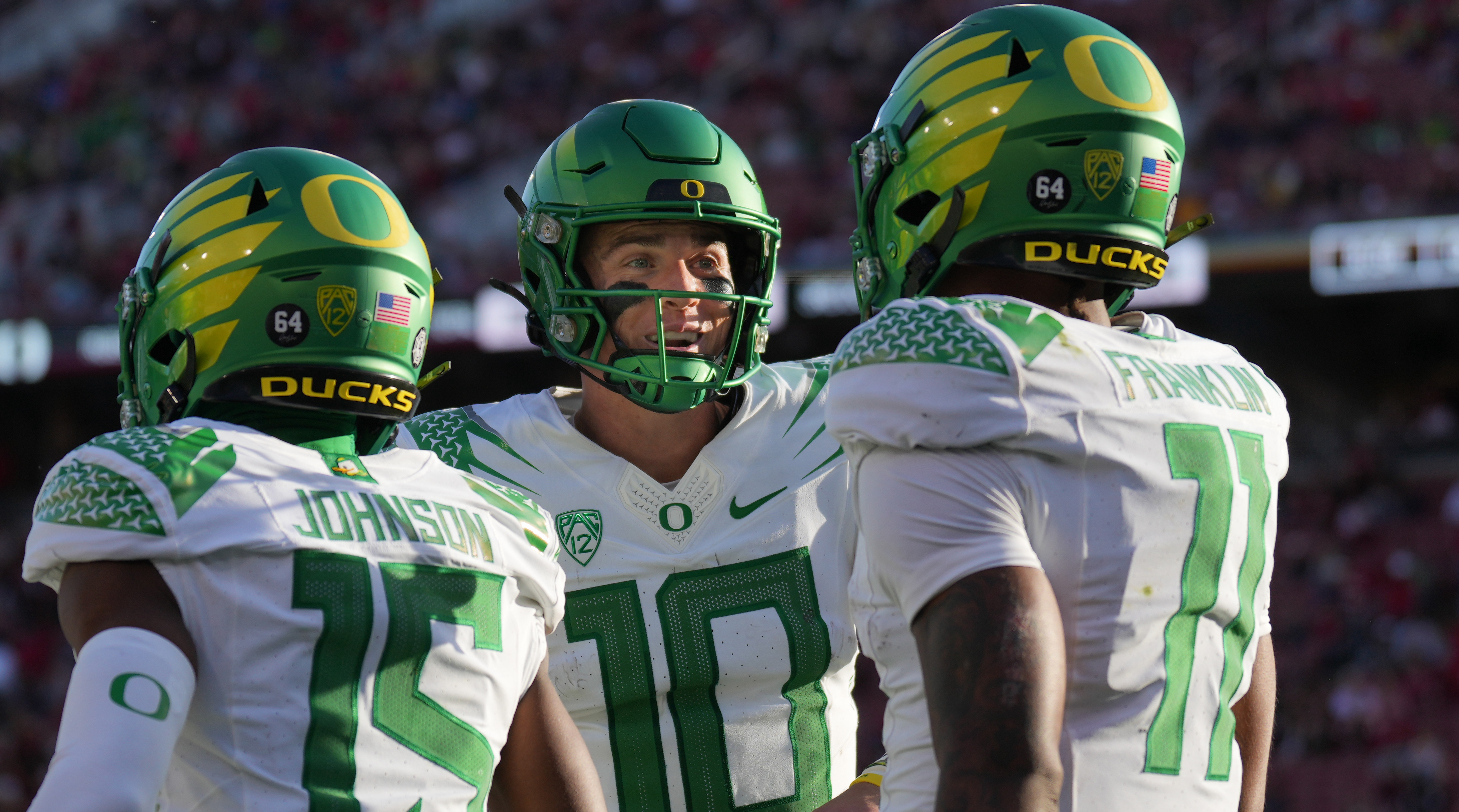 Oregon quarterback Bo Nix, center, congratulates wide receiver Troy Franklin, right, after a touchdown